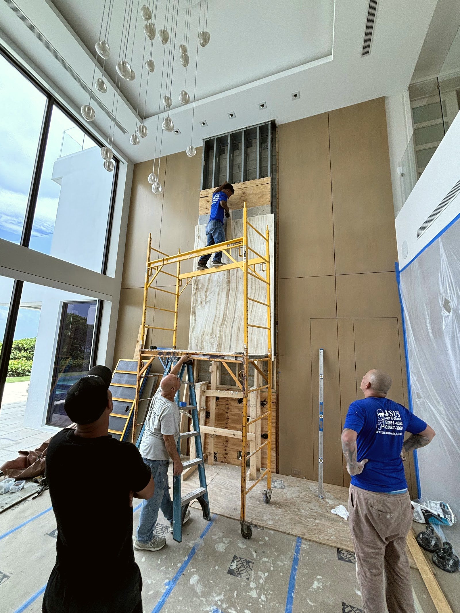 The Jesus Cabinets & Granite team installing a stone feature wall
